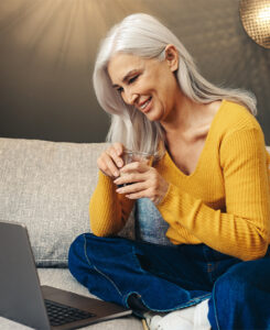 Woman engaged in Online Counseling through her computer with a cup of coffee
