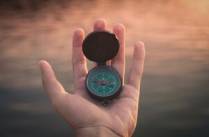 A hand holding a compass
