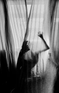 Person clawing at the curtains to escape